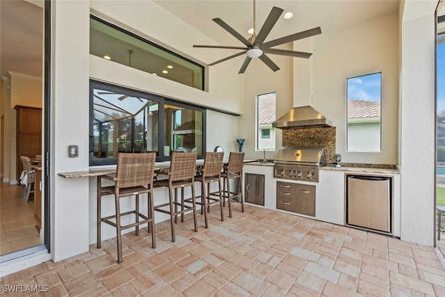 kitchen featuring ceiling fan, stainless steel refrigerator, sink, and a wealth of natural light