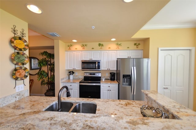 kitchen with appliances with stainless steel finishes, crown molding, light stone counters, white cabinets, and sink