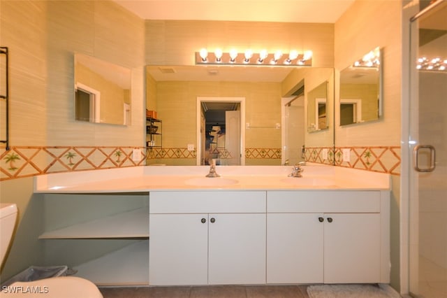 bathroom with tile walls, a shower with door, vanity, and toilet