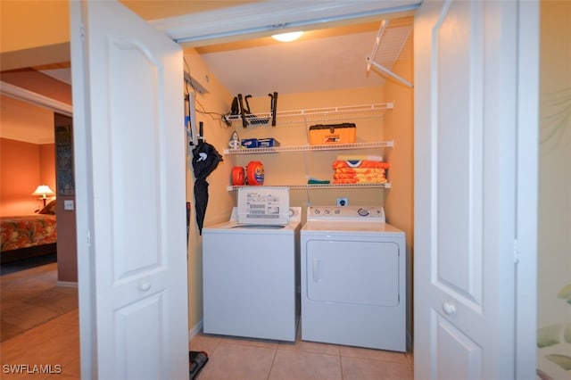 clothes washing area featuring separate washer and dryer and light tile patterned floors