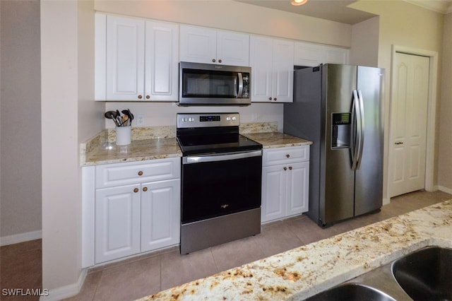 kitchen featuring white cabinetry, stainless steel appliances, and light tile patterned flooring