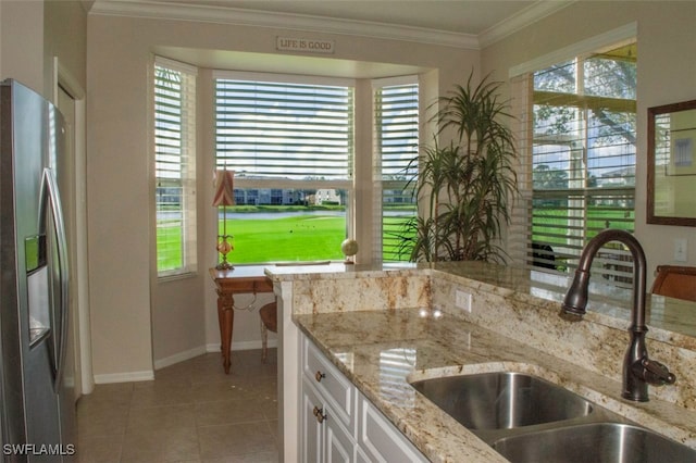 kitchen with white cabinetry, sink, stainless steel fridge with ice dispenser, crown molding, and light stone countertops