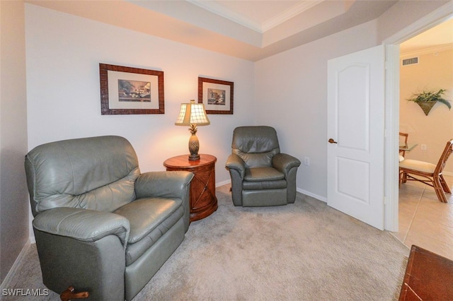 sitting room with crown molding, light colored carpet, and a raised ceiling