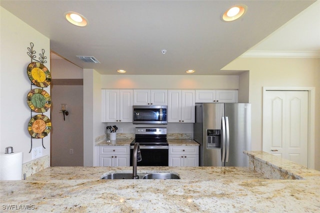 kitchen with sink, white cabinetry, stainless steel appliances, light stone counters, and ornamental molding