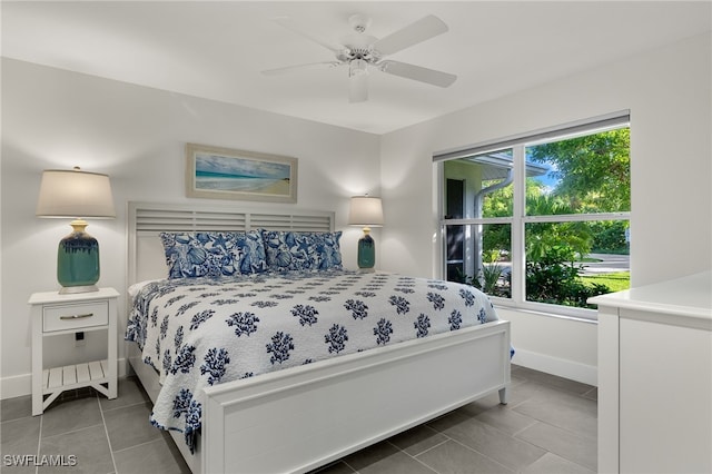 bedroom with tile patterned floors, baseboards, and a ceiling fan