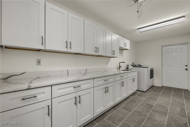 clothes washing area with washing machine and clothes dryer, cabinets, ceiling fan, and sink