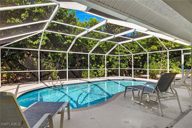 outdoor pool with a patio area and glass enclosure