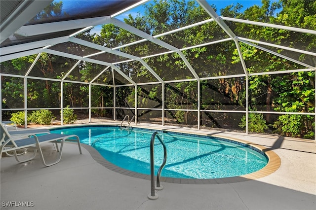 view of pool featuring glass enclosure and a patio