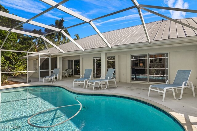 view of swimming pool with a patio area and glass enclosure