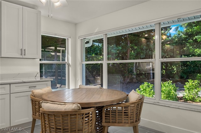 tiled dining space with ceiling fan