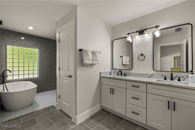 full bath with a soaking tub, double vanity, visible vents, and a sink