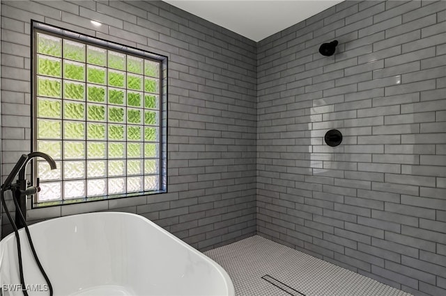 bathroom featuring a tile shower and a soaking tub