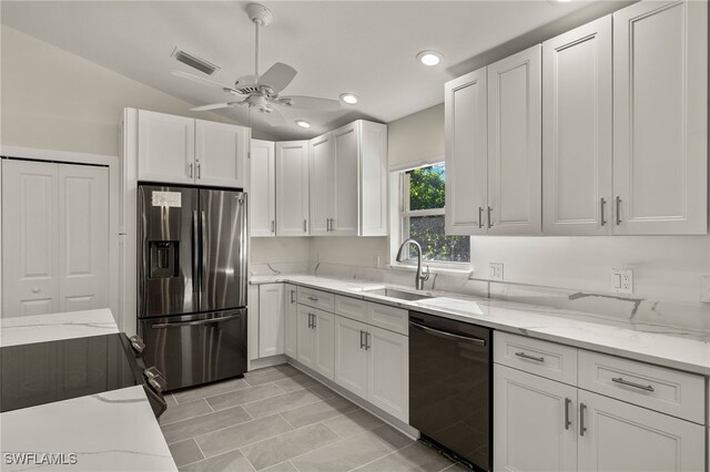 kitchen with black appliances, ceiling fan, light stone counters, and sink