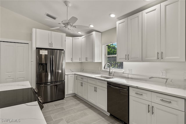 kitchen with white cabinetry, black appliances, light stone countertops, and a sink