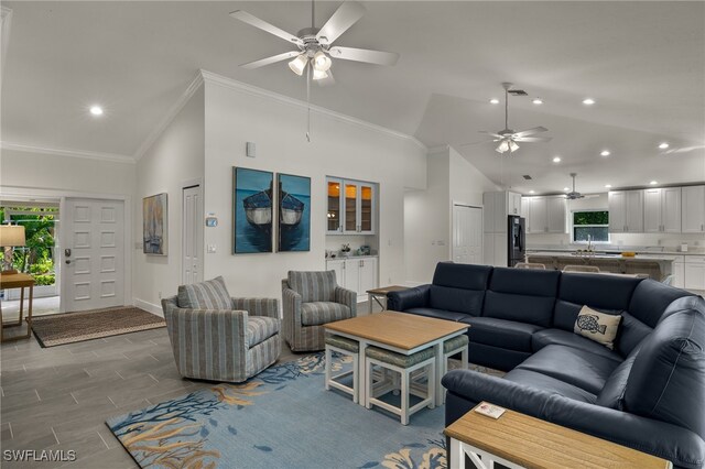 living room with ceiling fan, plenty of natural light, and crown molding