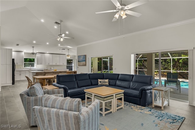 living room with ornamental molding, high vaulted ceiling, light tile patterned floors, and ceiling fan