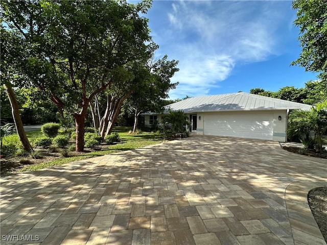 view of property exterior featuring an attached garage and decorative driveway