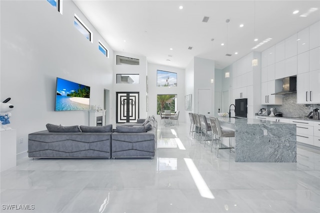 living room with sink and a high ceiling