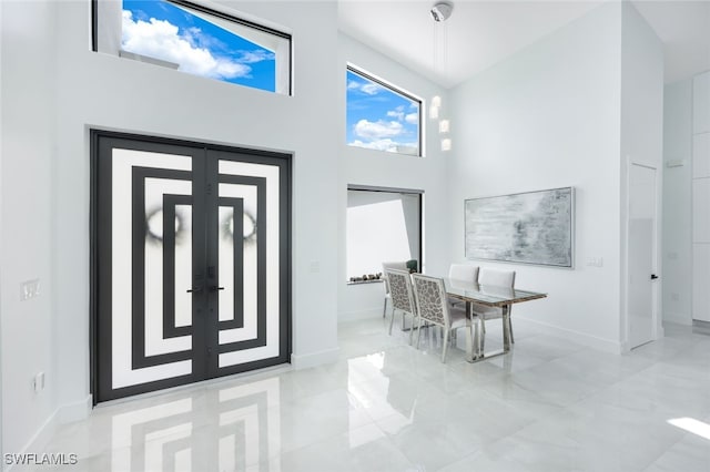 entryway with a towering ceiling and french doors