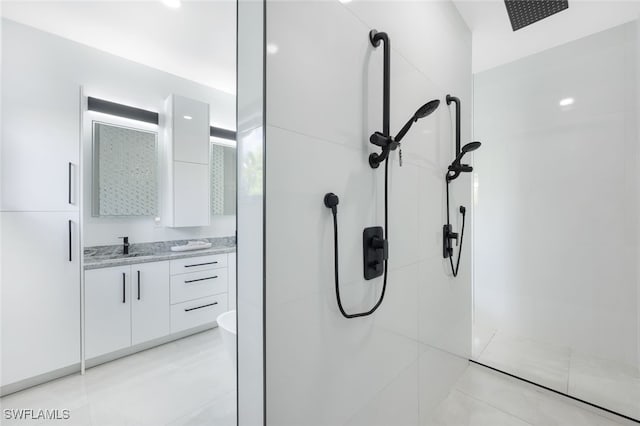 interior details featuring vanity, toilet, and tiled shower