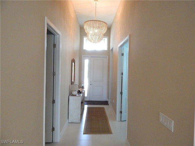 doorway to outside with a notable chandelier