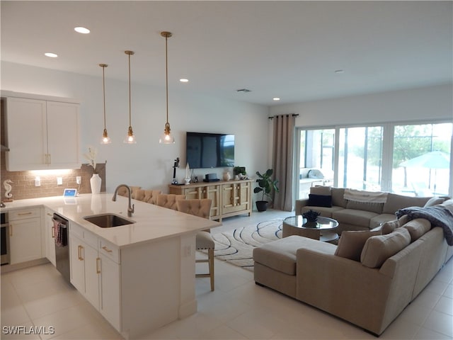 kitchen featuring stainless steel appliances, decorative light fixtures, kitchen peninsula, sink, and a breakfast bar area