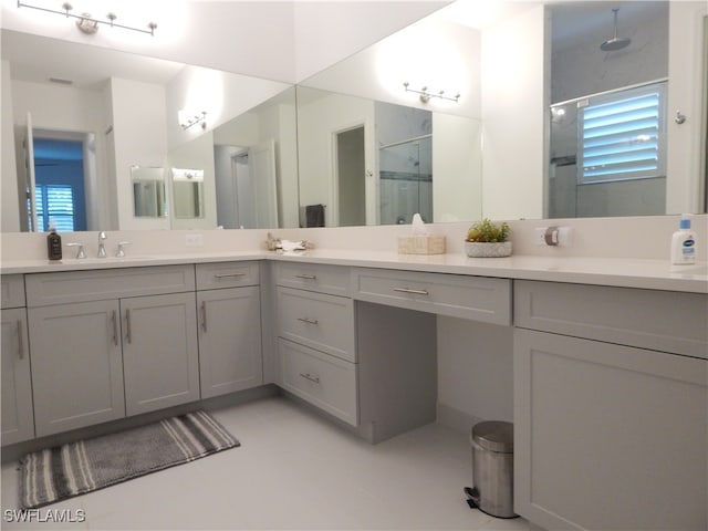 bathroom with a healthy amount of sunlight, a shower with door, and vanity