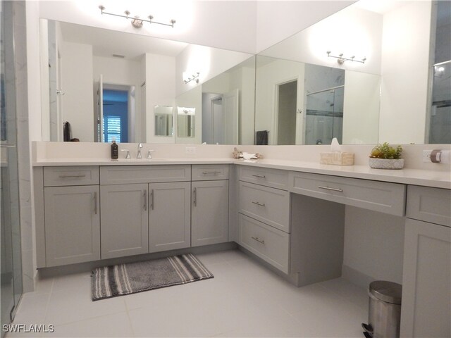 bathroom with vanity, an enclosed shower, and tile patterned floors