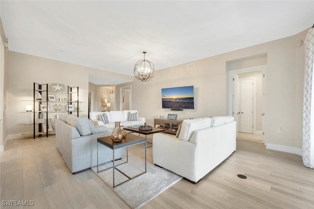 living room featuring light wood-type flooring and a notable chandelier