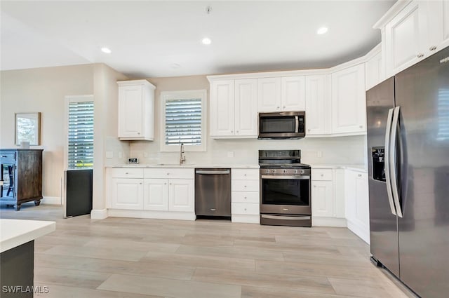 kitchen featuring sink, appliances with stainless steel finishes, and white cabinetry