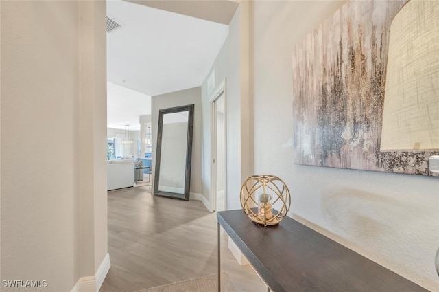 corridor with hardwood / wood-style flooring