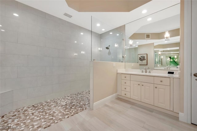 bathroom with vanity and a tile shower