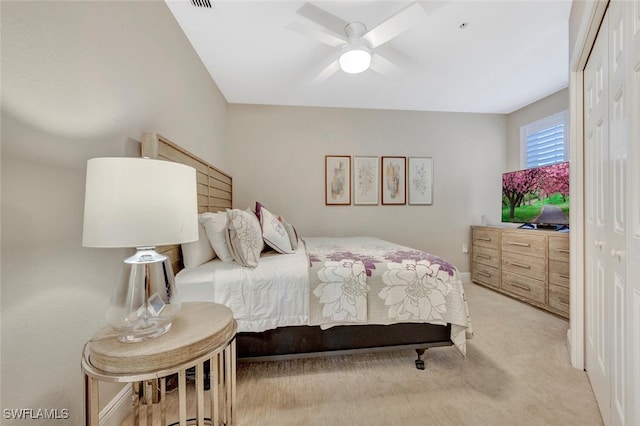 carpeted bedroom with ceiling fan and a closet