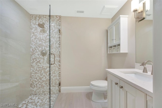 bathroom with vanity, toilet, and a shower with shower door