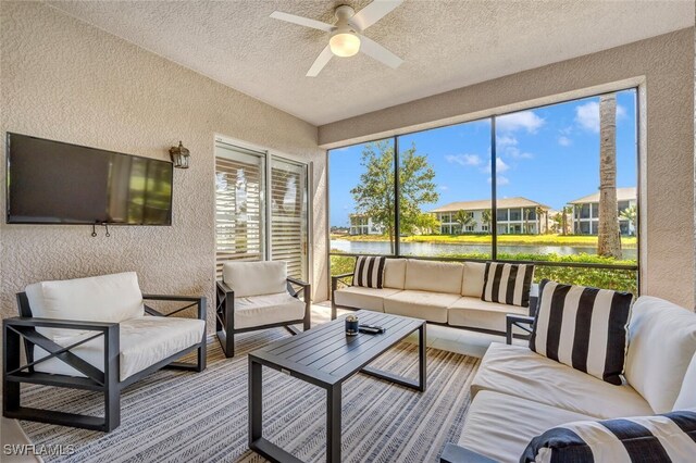 sunroom / solarium with a water view and ceiling fan