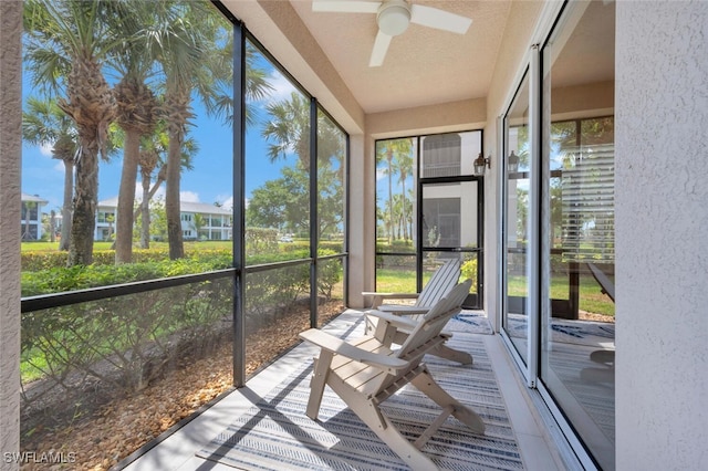 unfurnished sunroom featuring ceiling fan