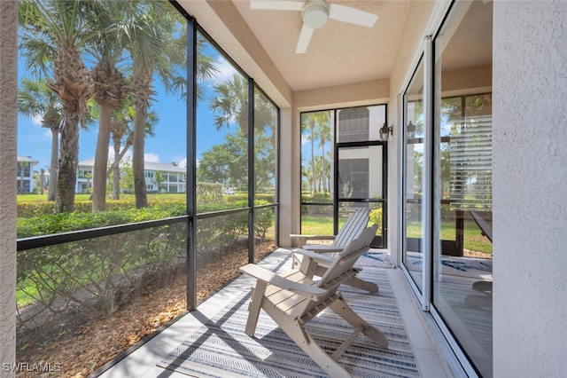 unfurnished sunroom with ceiling fan