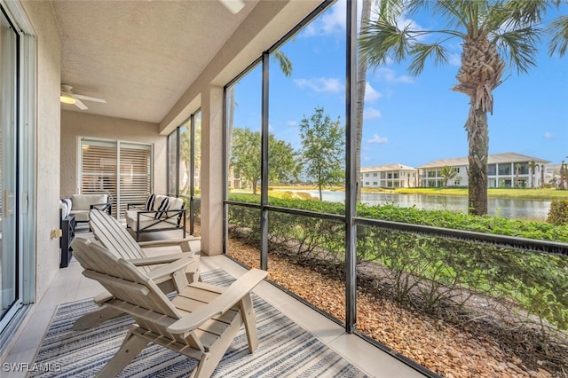 sunroom / solarium with a water view and ceiling fan