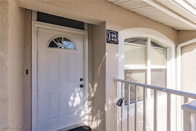 property entrance with stucco siding