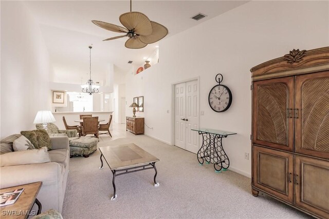 living room featuring ceiling fan with notable chandelier, high vaulted ceiling, and light colored carpet