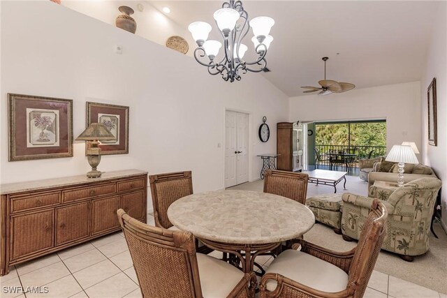 tiled dining room with vaulted ceiling and ceiling fan with notable chandelier