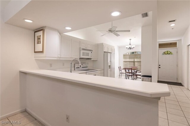 kitchen featuring ceiling fan with notable chandelier, white appliances, white cabinetry, light tile patterned floors, and kitchen peninsula