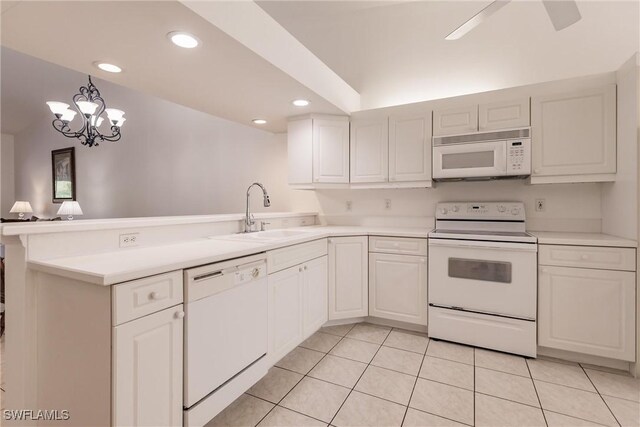 kitchen with kitchen peninsula, sink, white appliances, and white cabinets