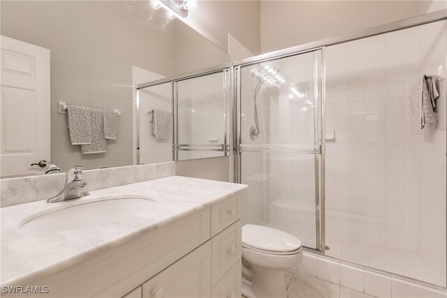 bathroom with vanity, toilet, and an enclosed shower