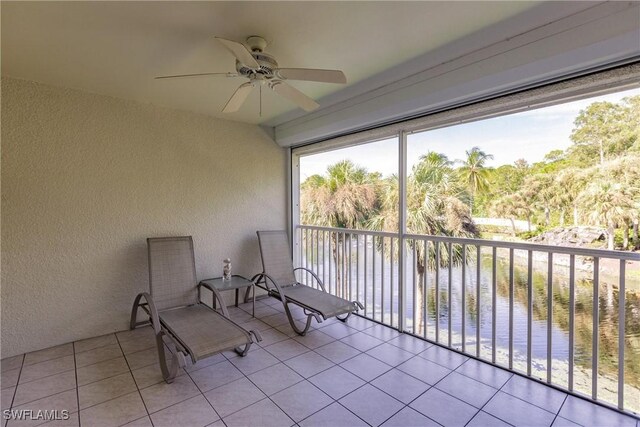 sunroom with a water view and ceiling fan