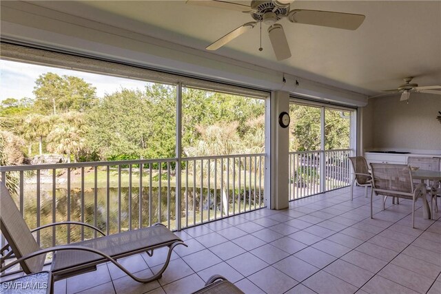 unfurnished sunroom with a water view and ceiling fan