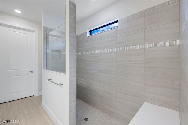 bathroom with baseboards, a walk in shower, and wood finished floors