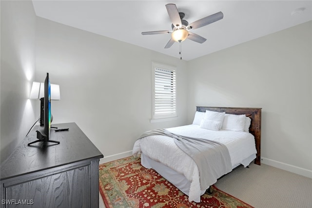 bedroom featuring ceiling fan, light colored carpet, and baseboards