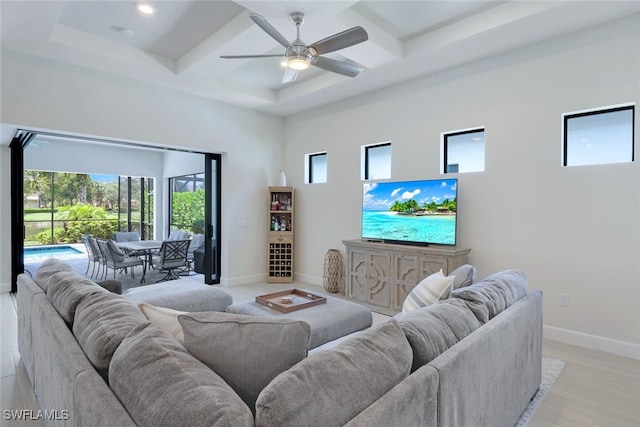 living area with ceiling fan, a high ceiling, recessed lighting, and baseboards