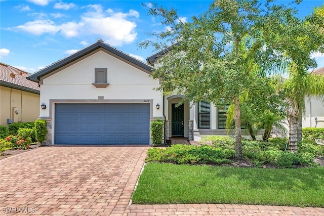 view of front of house with a garage, decorative driveway, and stucco siding